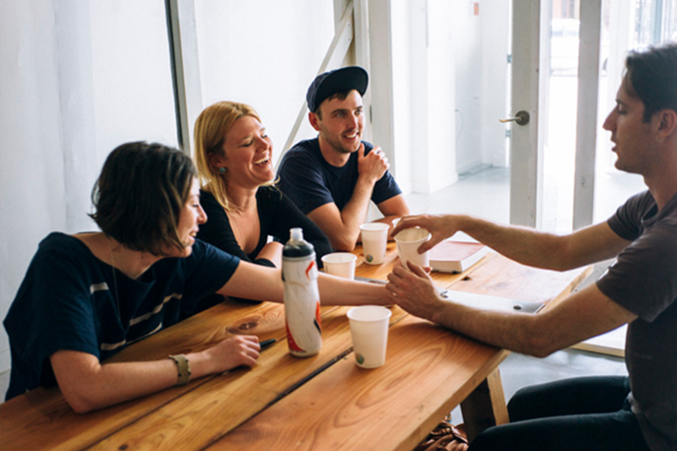 Two women and two men sitting at a table, enjoying their conversation at the Faraday Cafe.