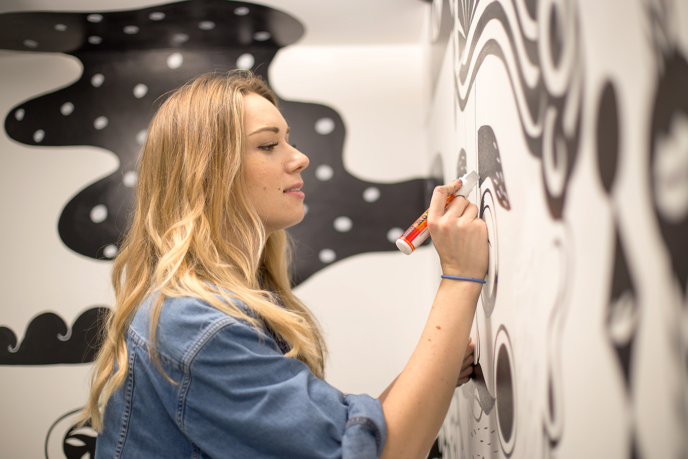Ola Volo working on a detail of her mural in the hcma Vancouver office lobby.