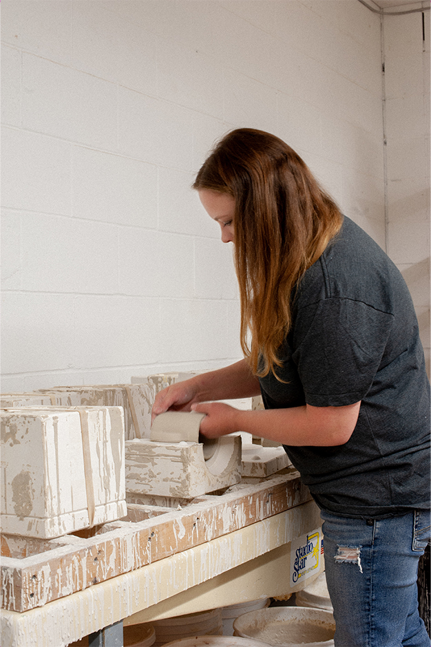 Mindy Doke taking an hcma mug out of its mould.