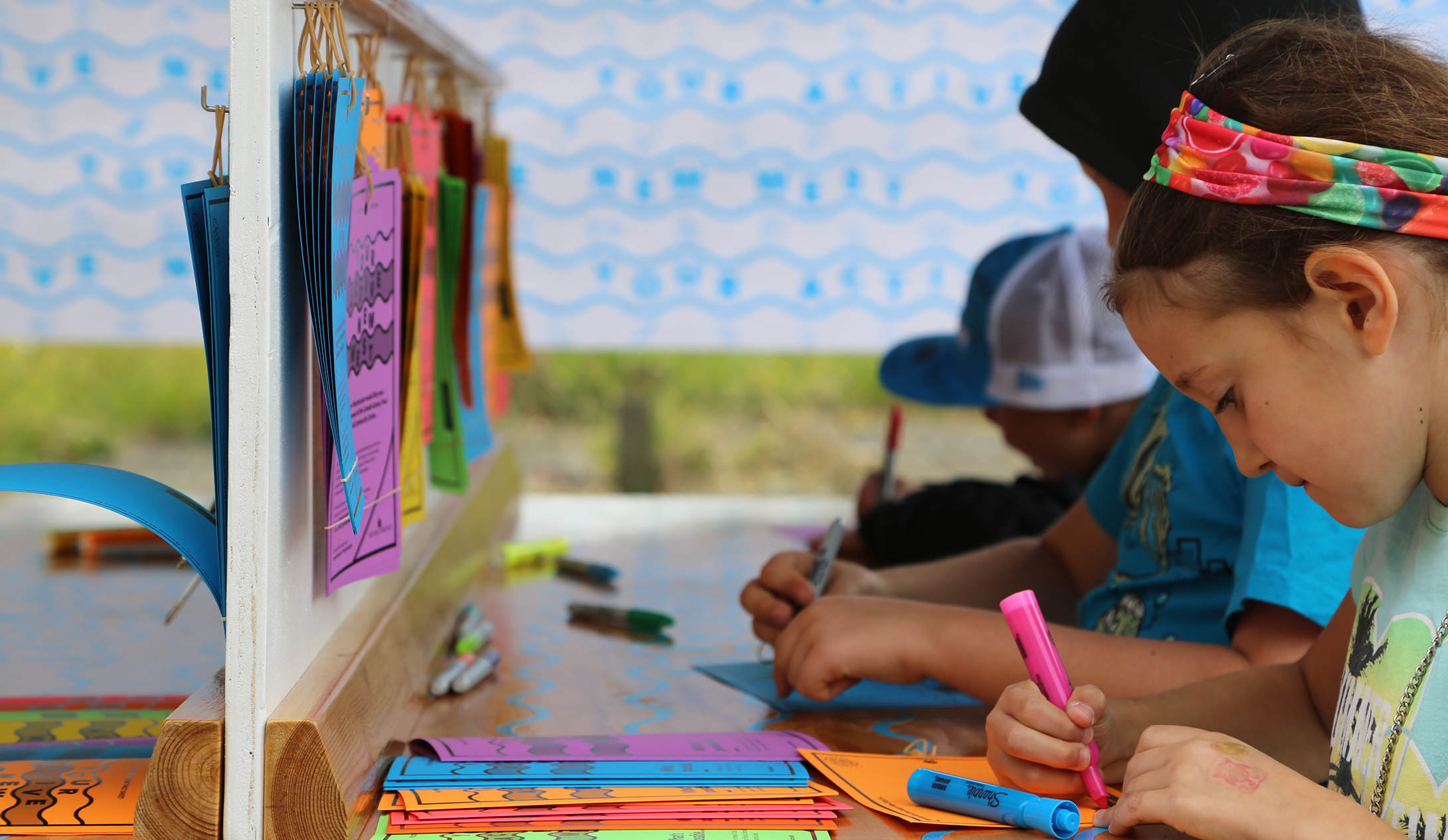 Little girls and boys highlighting words on colourfully designed cards.