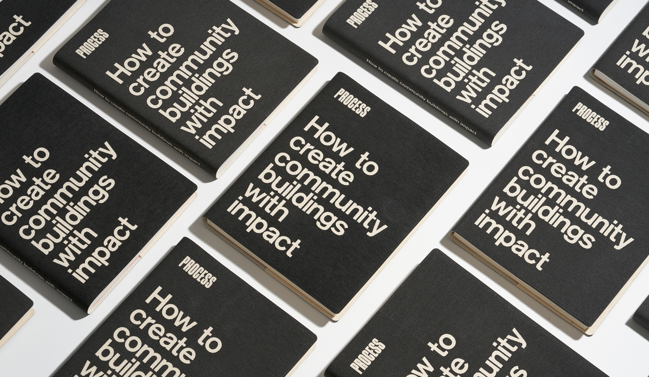 A black book repeated on a table that says "Process: How to create community buildings with impact"