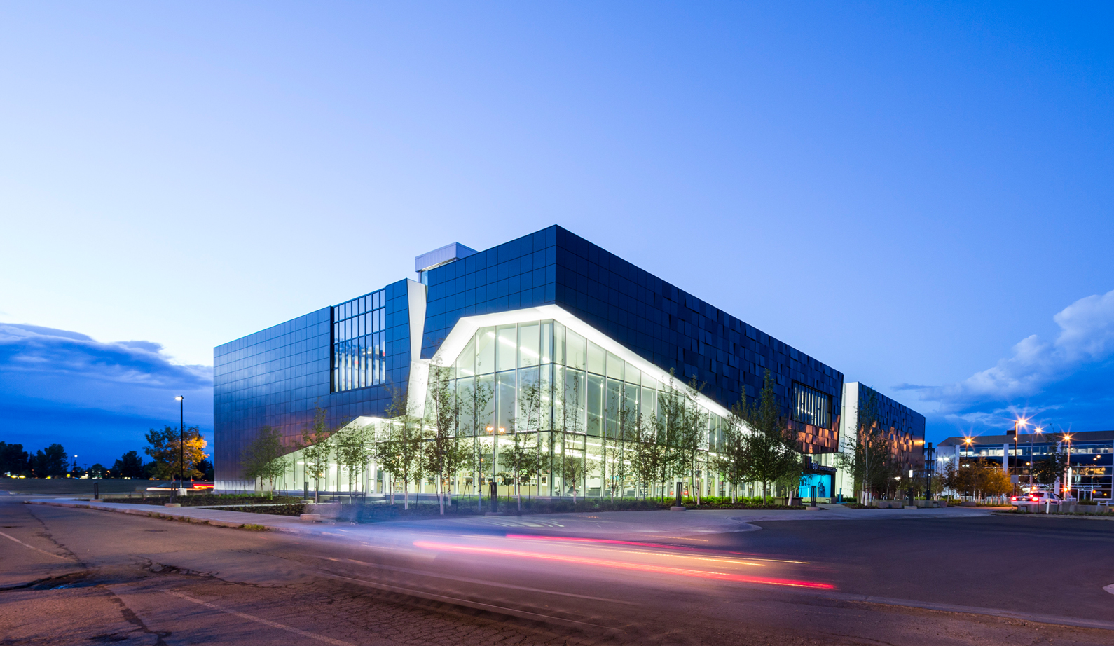 This shot of the brightly lit interior of Mill Woods Library at night highlights the cut-out feature corner of the building.