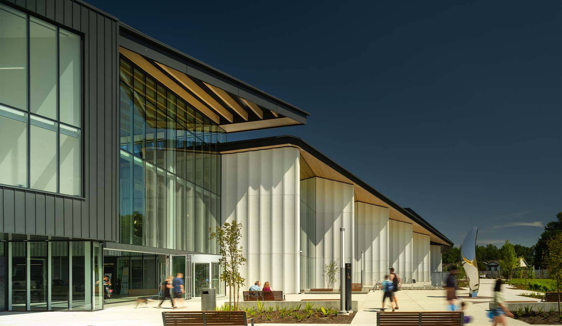 təməsew̓txʷ Aquatic and Community Centre south plaza highlighting the ravine space and Miyíw̓ts sculpture