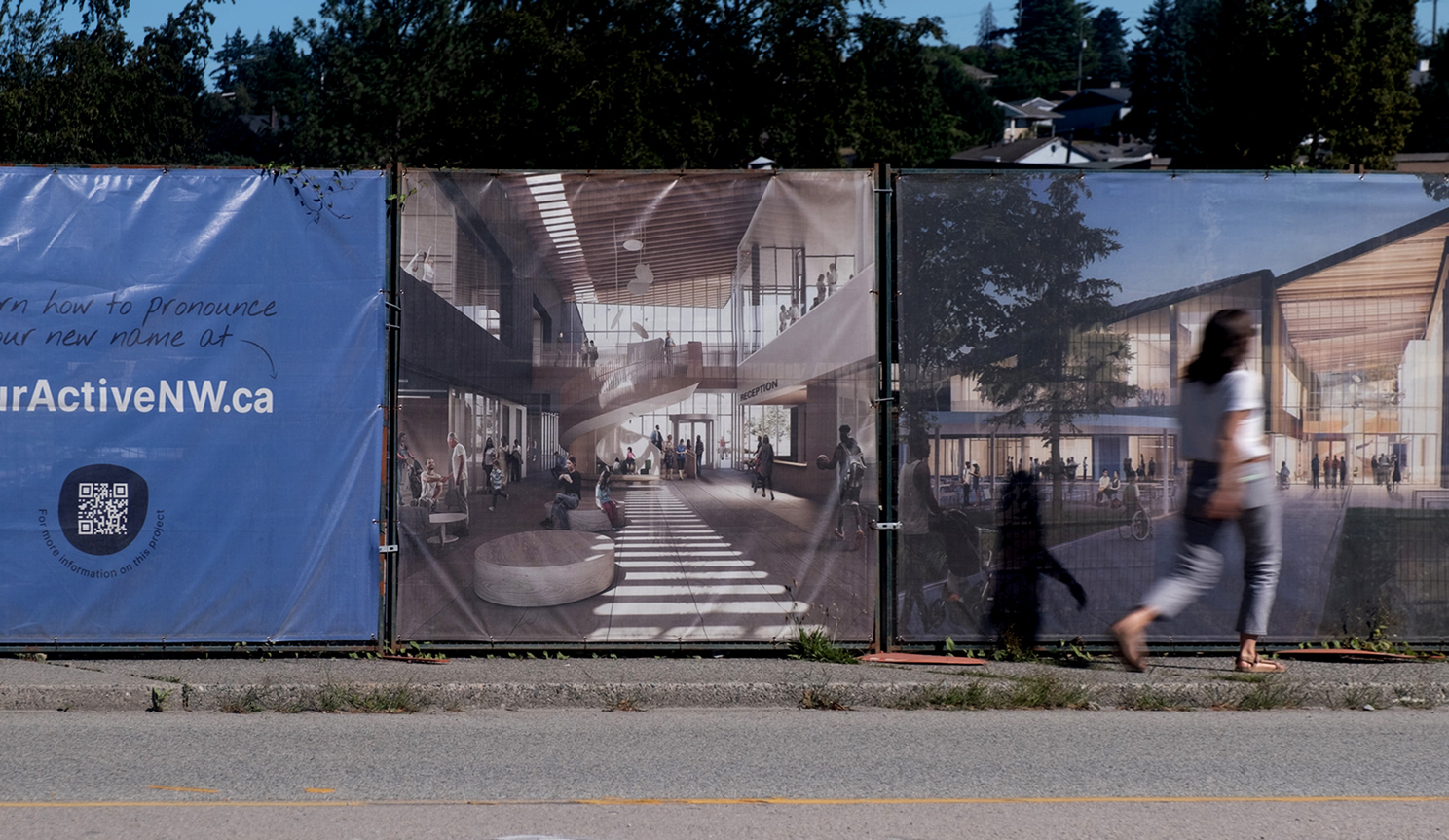Fence hoarding with someone walking by.