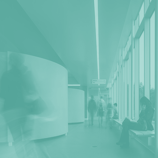 Interior double-page photo of people in a hallway of a public building.