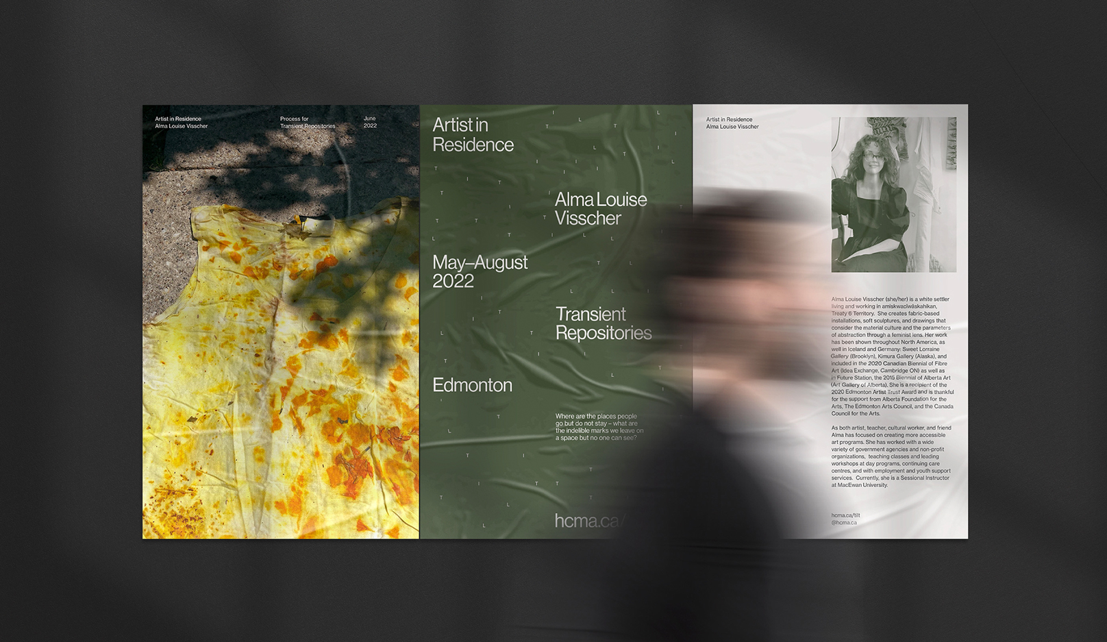 Someone walking past posters about an artist in residence–Alma Louise Visscher.