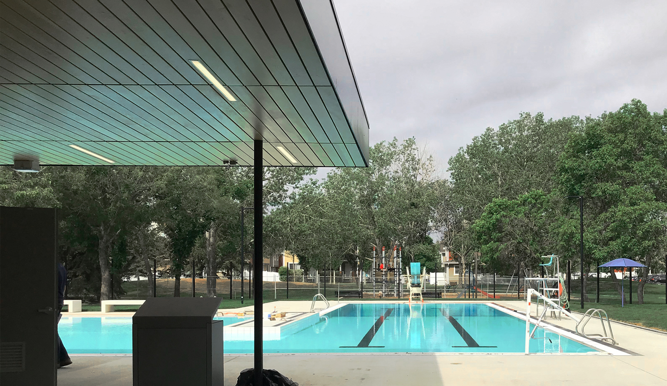 A view of the Maple Leaf Outdoor Pool. It is surrounded by trees and greenery.